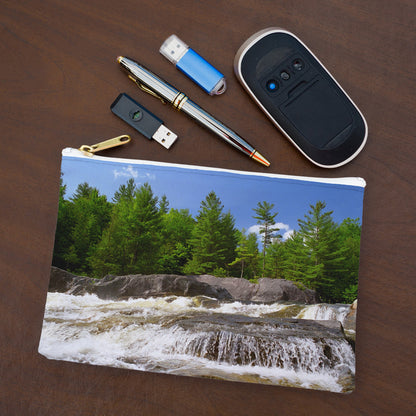 Small pouch with forest waterfall design lying flat on desktop with thumb drives, computer mouse and pen.
