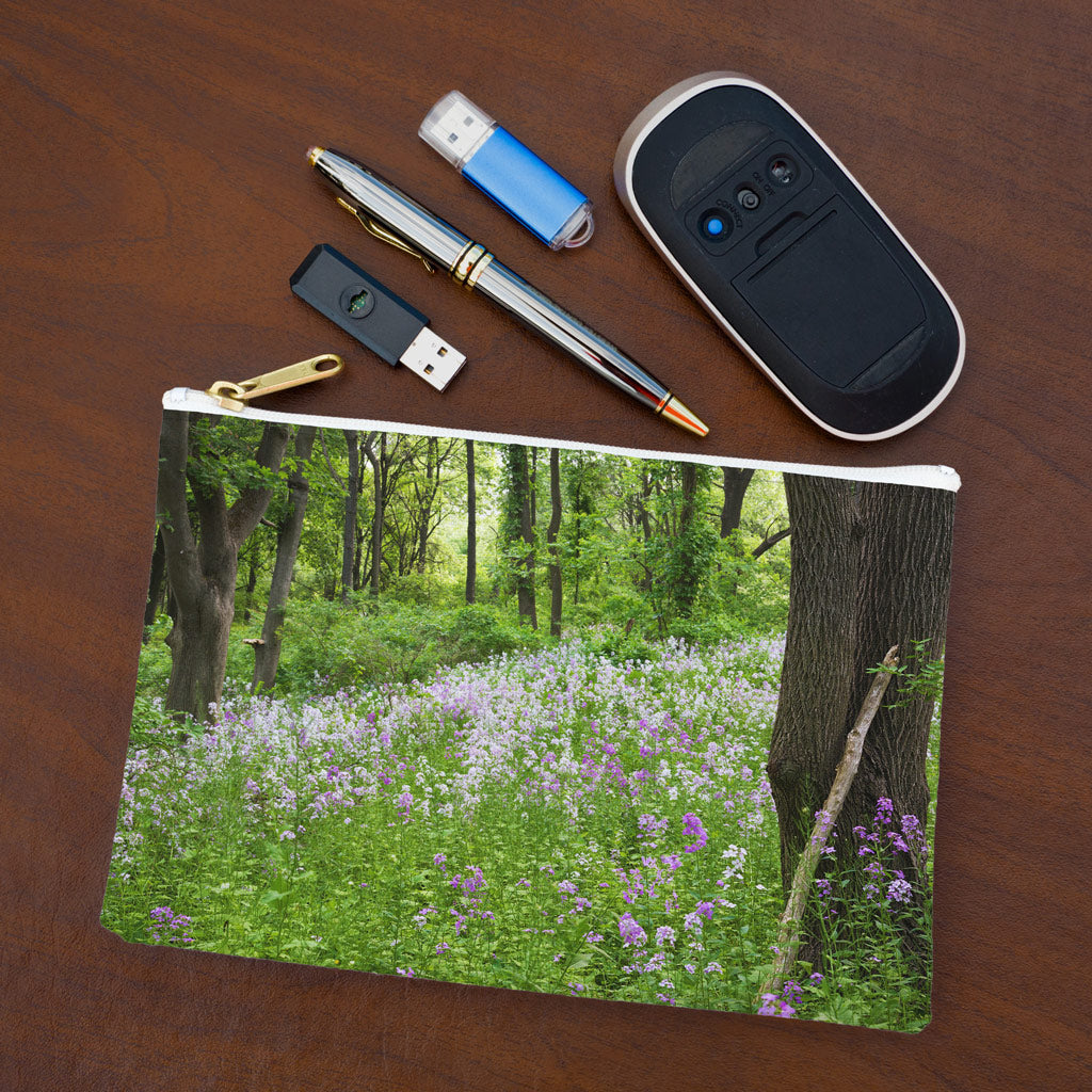 Small pouch with forest wildflowers design lying flat on desktop with thumb drives, computer mouse and pen.