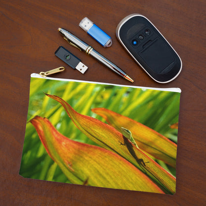 Small pouch with sunlit gecko design lying flat on desktop with thumb drives, computer mouse and pen.