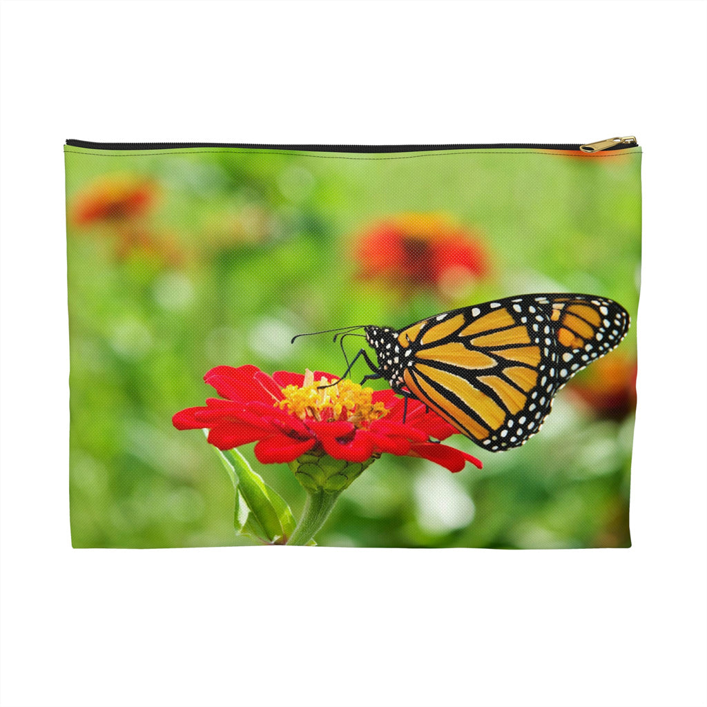 Zippered accessory pouch featuring vibrant photo art close up of a monarch butterfly perched on a large red flower.