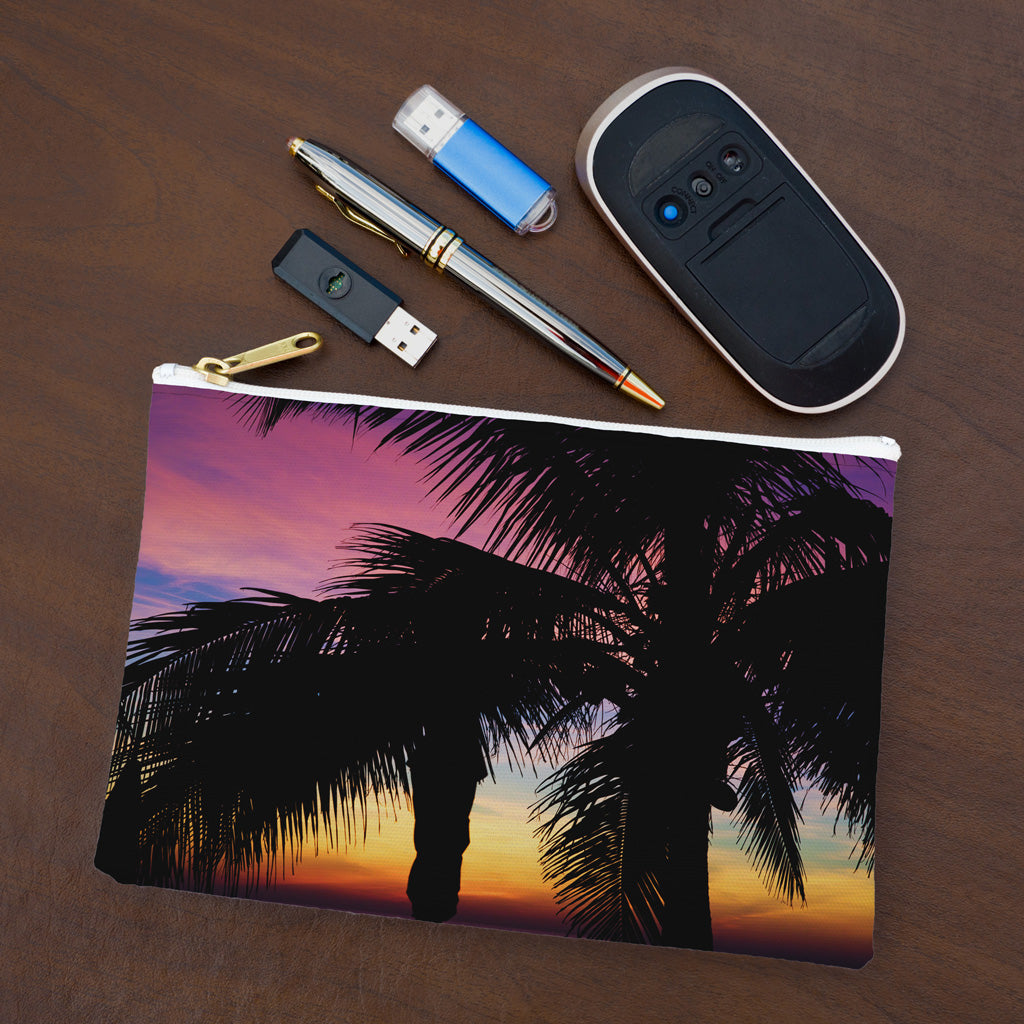 Small pouch with intense sunset design lying flat on desktop with thumb drives, computer mouse and pen.