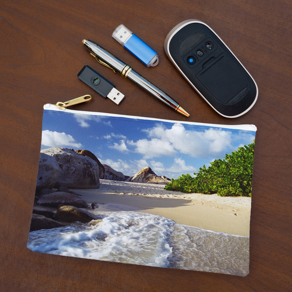 Small pouch with beach surf design lying flat on desktop with thumb drives, computer mouse and pen.