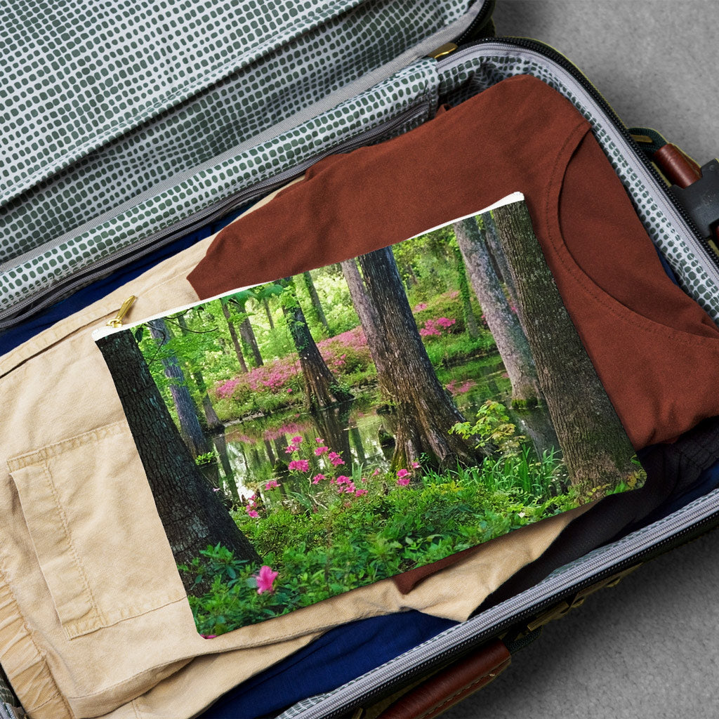 Large pouch with wetland design lying flat atop the contents of an open suitcase.