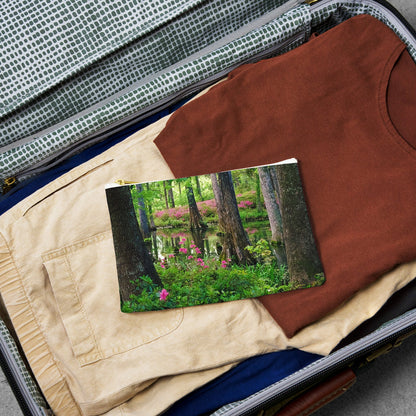 Small pouch with wetland design lying flat atop the contents of an open suitcase.