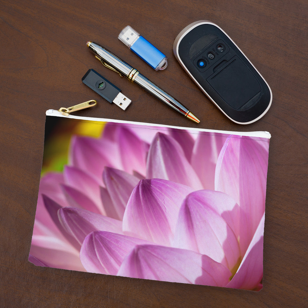 Small pouch with flower petals design lying flat on desktop with thumb drives, computer mouse and pen.