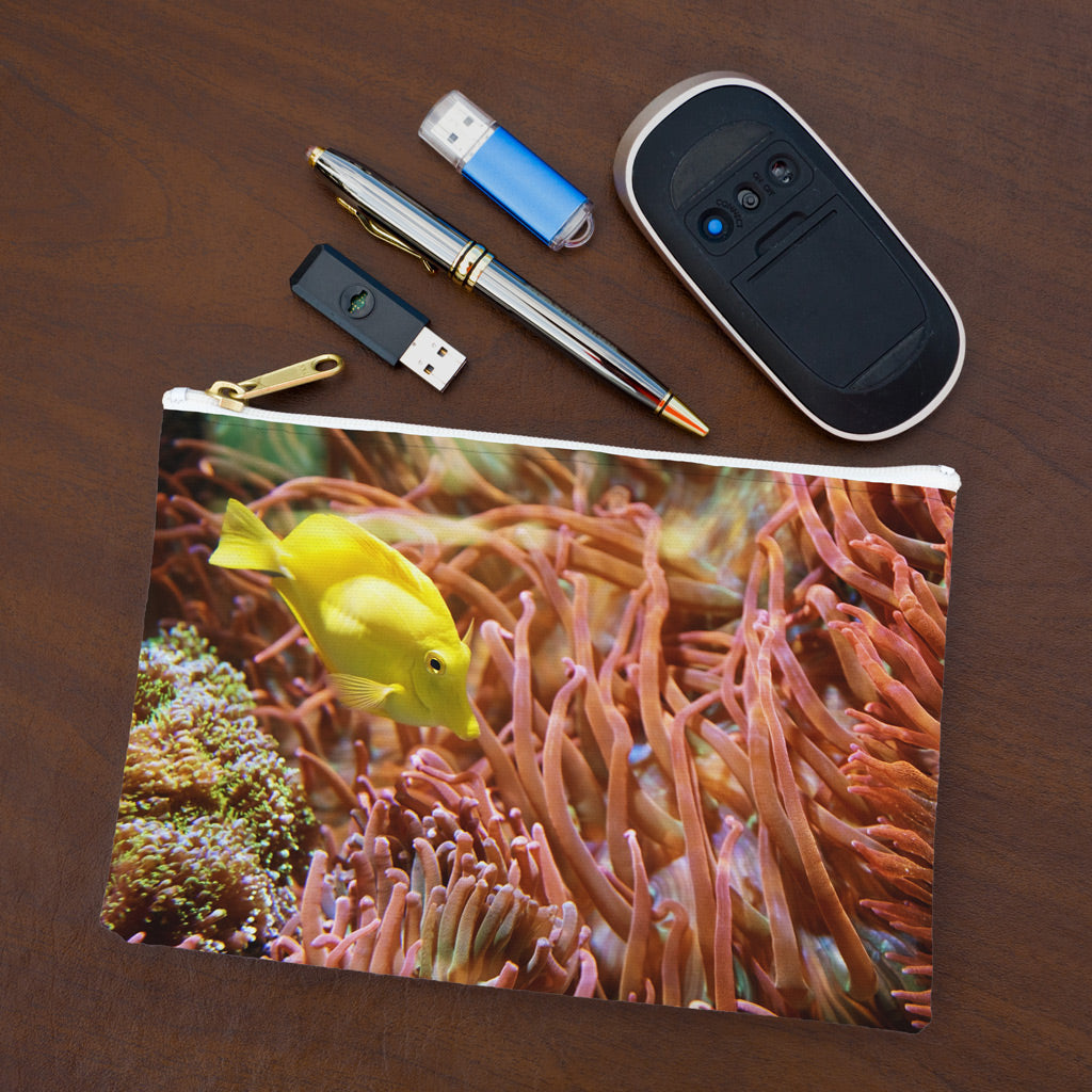 Small pouch with yellow fish design lying flat on desktop with thumb drives, computer mouse and pen.