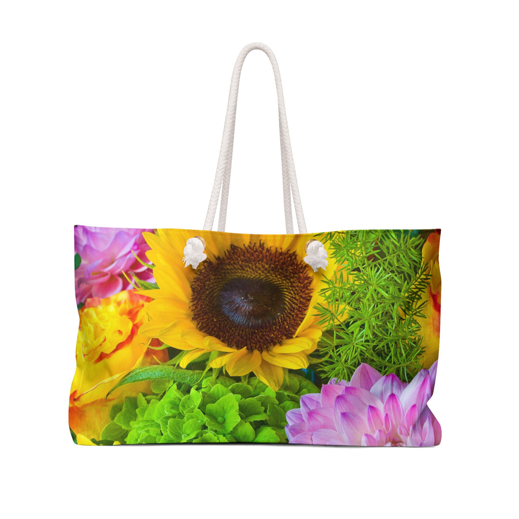Front view of a beach bag featuring vibrant photo art of sunflower amid tight cluster of brilliantly colored blooms.