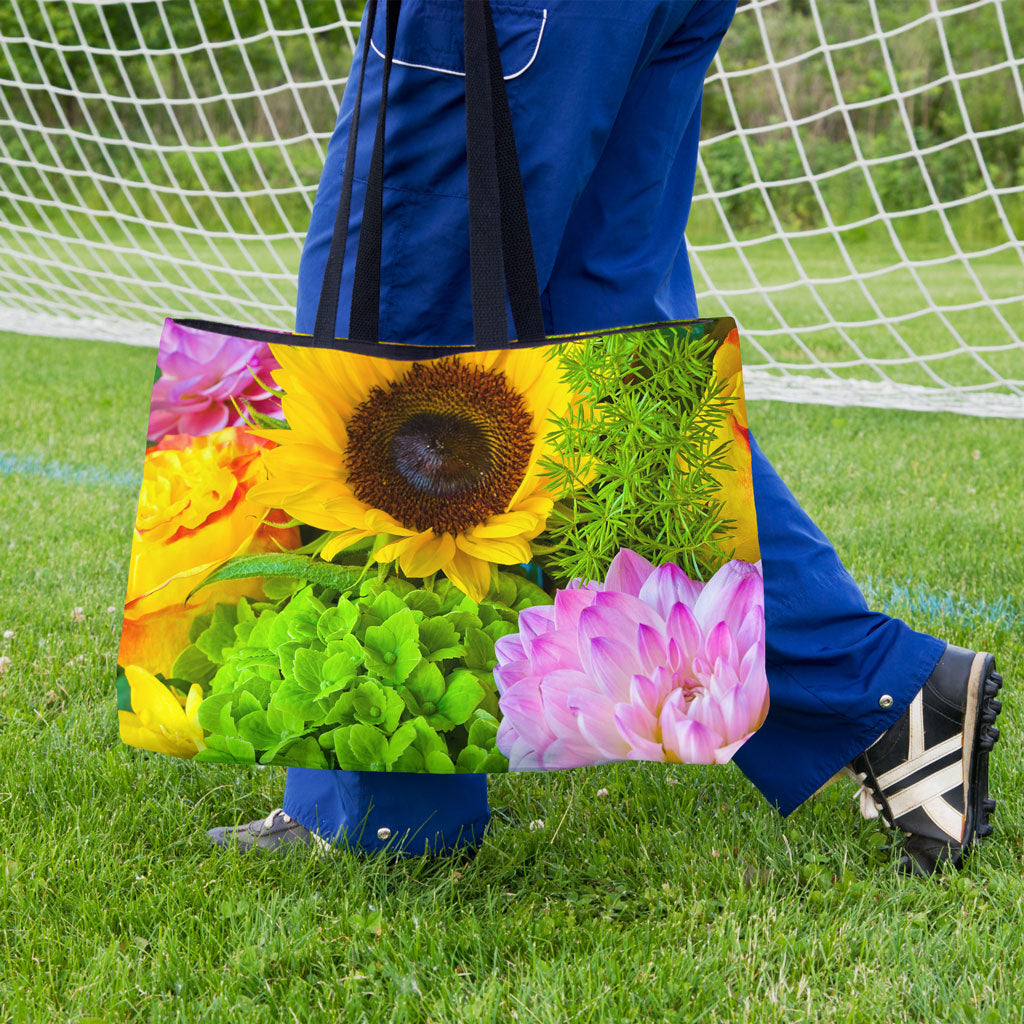 A soccer player carrying a weekender bag featuring the flower bouquet design onto the practice field.