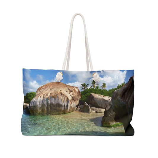 Front view of a beach bag featuring vibrant photo art of Caribbean beach calm turquoise pool sheltered by huge boulders.
