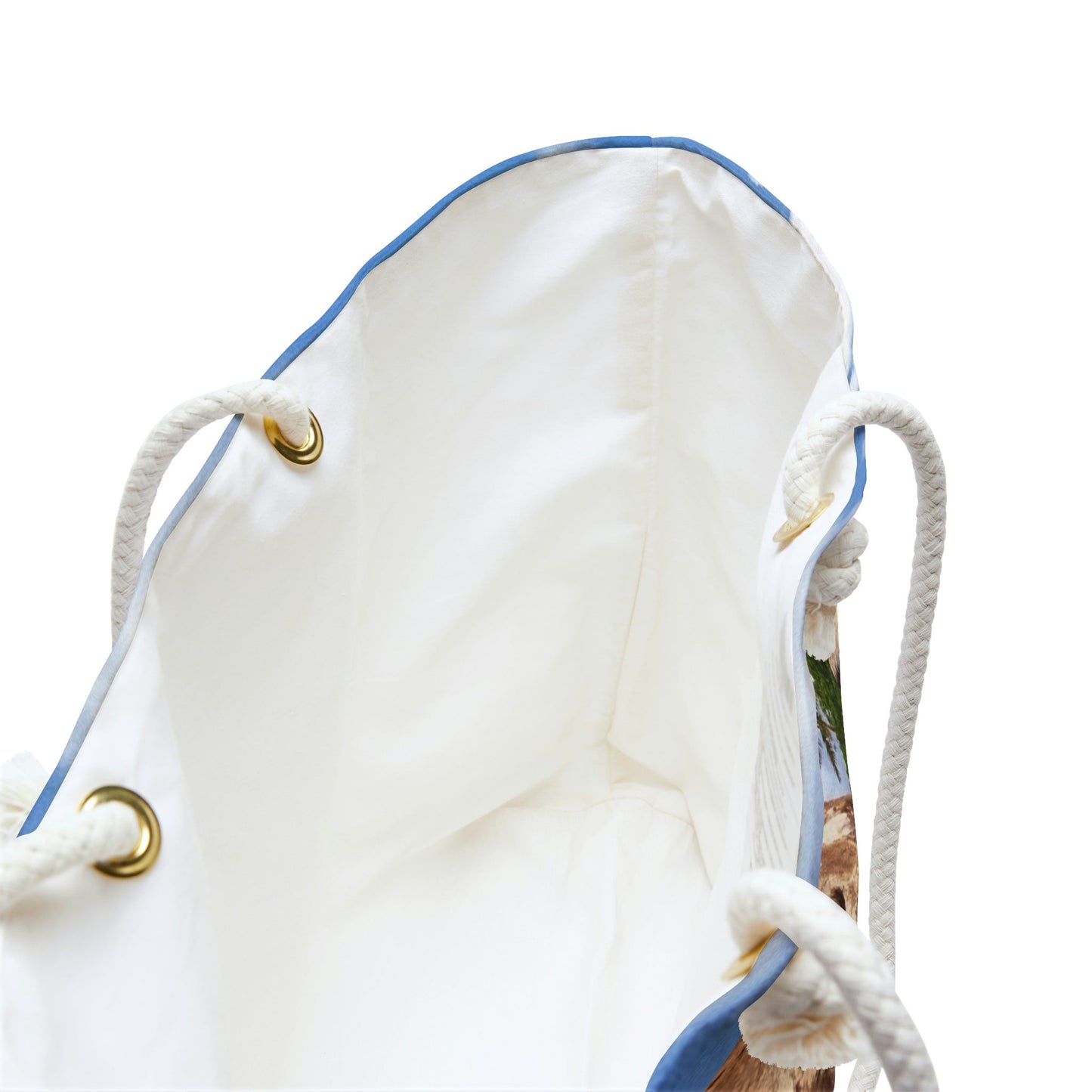A close up view of the beach bag with calm turquoise water design shows the braided rope handles with metal grommets.
