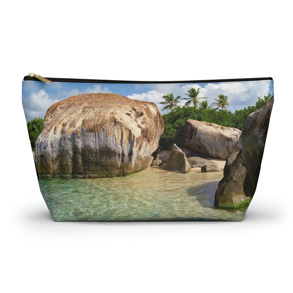 Zippered accessory pouch featuring vibrant photo art of Caribbean beach calm turquoise pool sheltered by huge boulders.