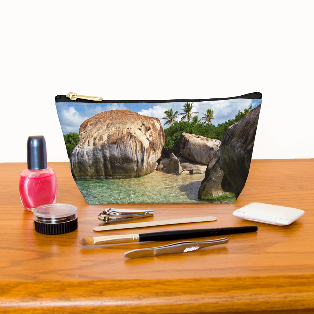 Kit bag with calm turquoise water design next to nail polish, tweezers, nail clippers, makeup brush, blush and eye shadow.