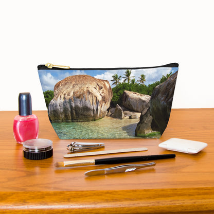 Kit bag with calm turquoise water design next to nail polish, tweezers, nail clippers, makeup brush, blush and eye shadow.