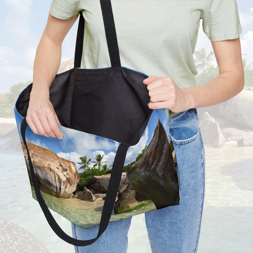 A woman holding open a weekender bag featuring the calm turquoise water design, showcasing the roomy interior.