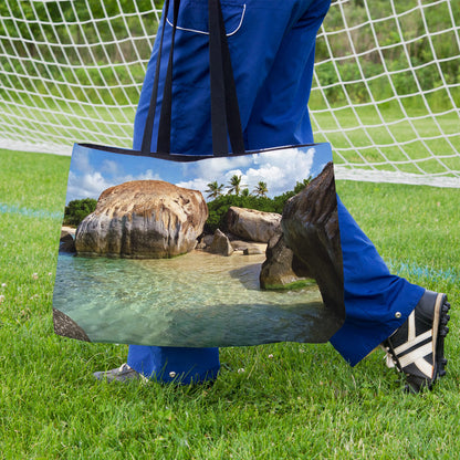 A soccer player carrying a weekender bag featuring the calm turquoise water design onto the practice field.