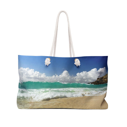 Front view of a beach bag featuring vibrant photo art of a vast turquoise Caribbean wave cresting about to crash on the beach.