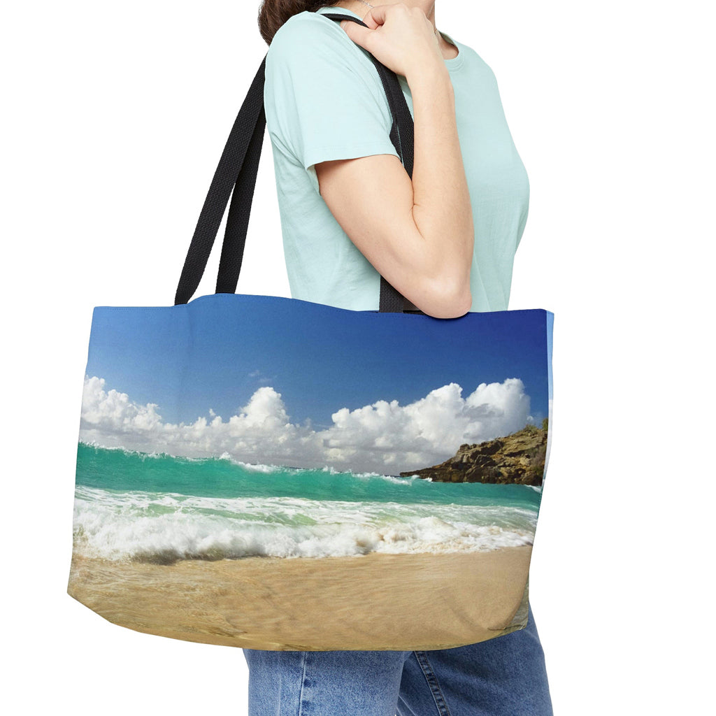 Young woman with a weekender bag featuring the crashing waves design hanging from her shoulder.