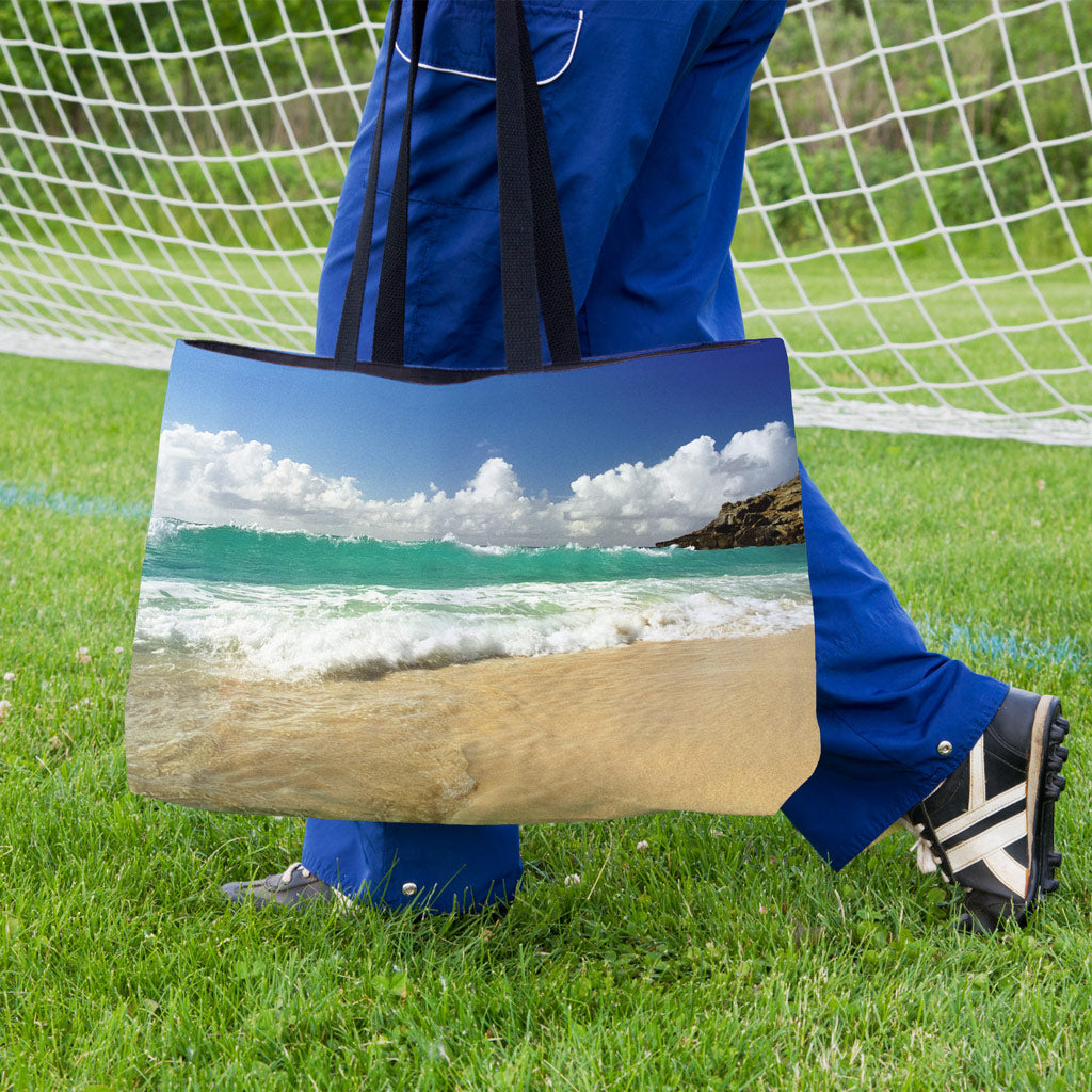 A soccer player carrying a weekender bag featuring the crashing waves design onto the practice field.