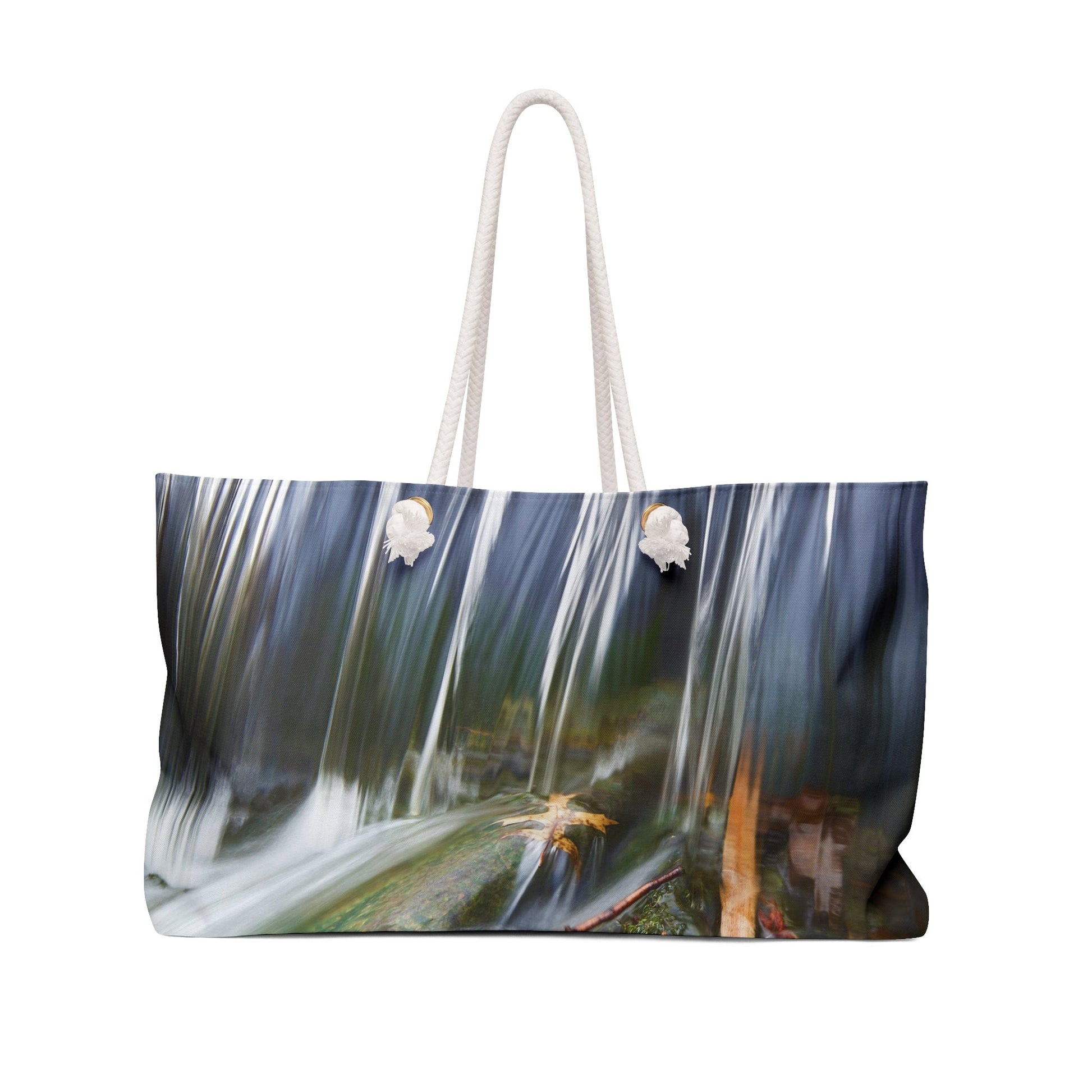 Front view of a beach bag featuring vibrant photo art of a swift creek waterfall striking fall leaves in the rock bed.