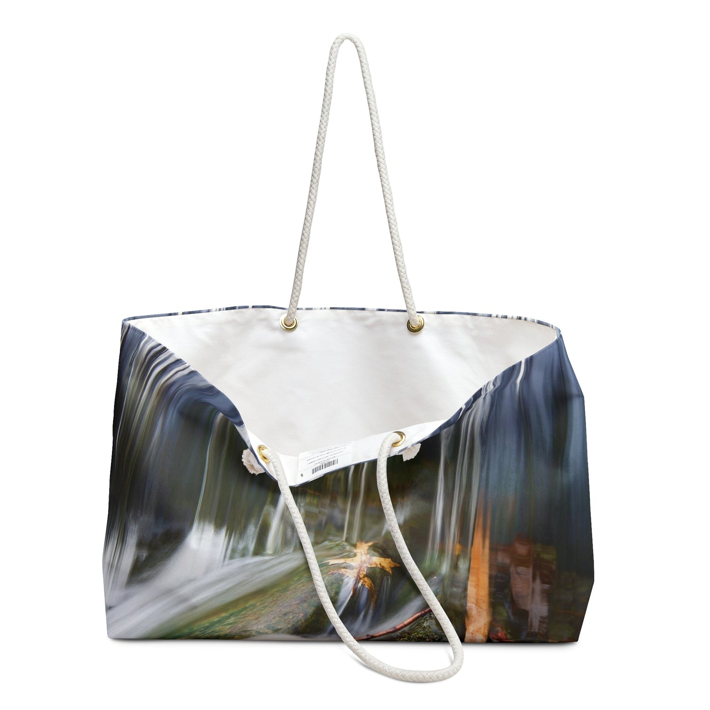 An open view of the beach bag with creek waterfall design shows the cream colored interior lining.