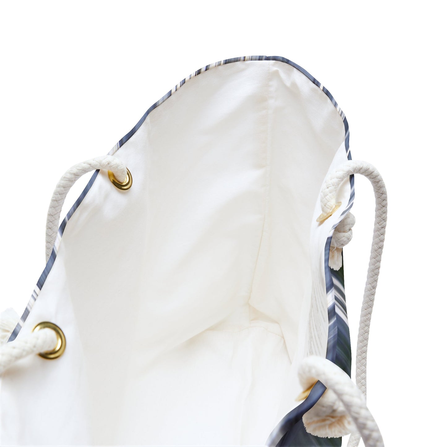 A close up view of the beach bag with creek waterfall design shows the braided rope handles with metal grommets.