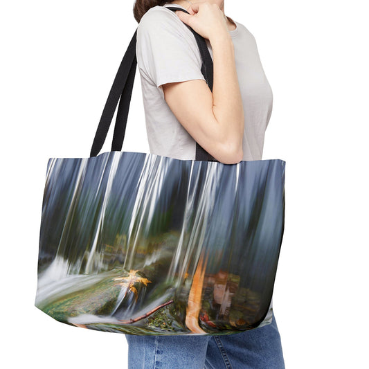 Young woman with a weekender bag featuring the creek waterfall design hanging from her shoulder.
