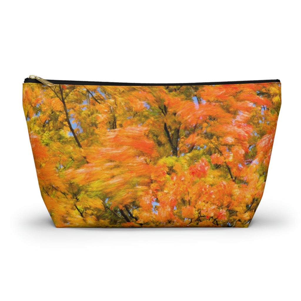 Zippered accessory pouch featuring vibrant photo art of intense fall colored trees swaying wildly in a gusty wind.