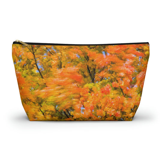 Zippered accessory pouch featuring vibrant photo art of intense fall colored trees swaying wildly in a gusty wind.