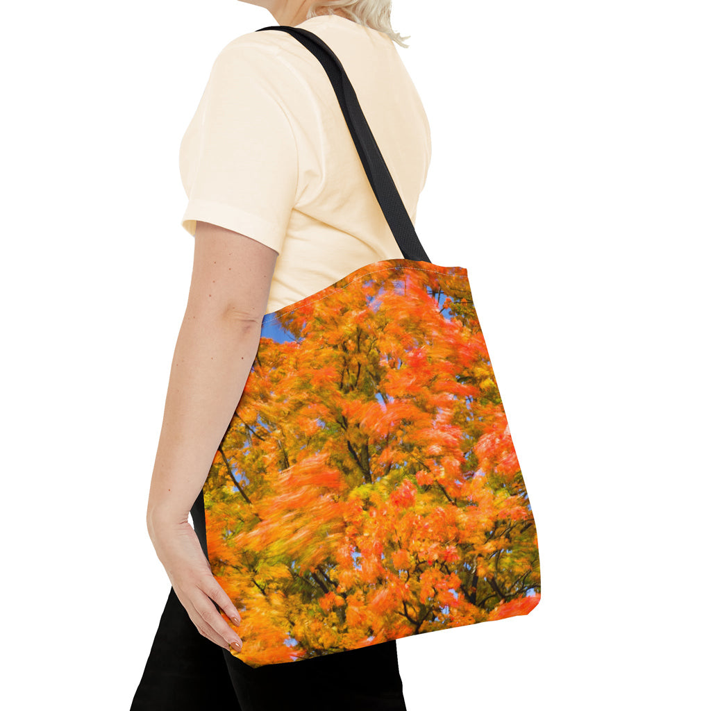 Young woman with a tote bag featuring the fall colored trees design draped across her shoulder.