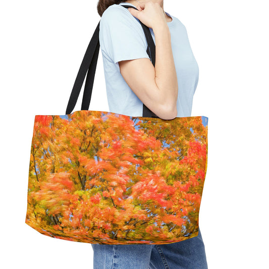 Young woman with a weekender bag featuring the fall colored trees design hanging from her shoulder.