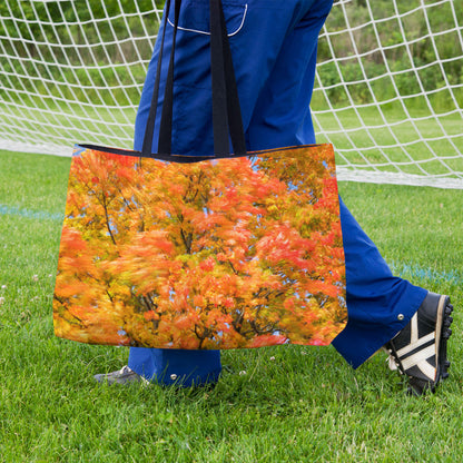 A soccer player carrying a weekender bag featuring the fall colored trees design onto the practice field.