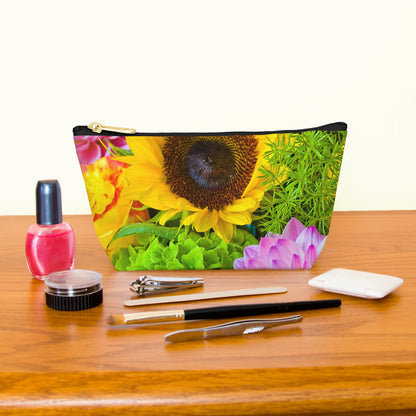 Kit bag with flower bouquet design next to nail polish, tweezers, nail clippers, makeup brush, blush and eye shadow.
