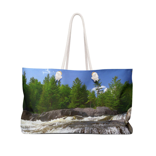Front view of a beach bag featuring vibrant photo art of lush green forest at the edge of a raging Adirondack waterfall.