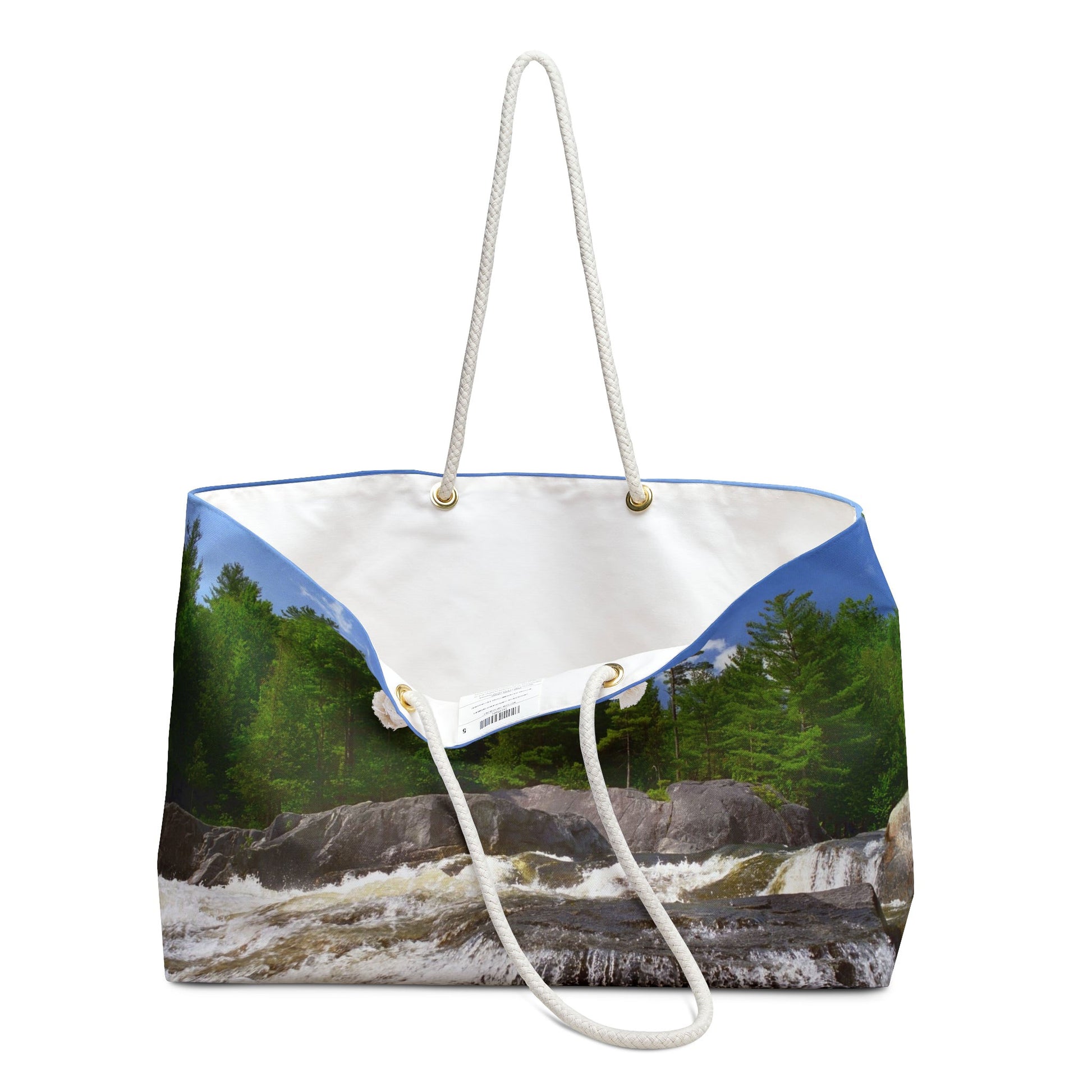 An open view of the beach bag with forest waterfall design shows the cream colored interior lining.
