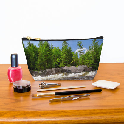 Kit bag with forest waterfall design next to nail polish, tweezers, nail clippers, makeup brush, blush and eye shadow.