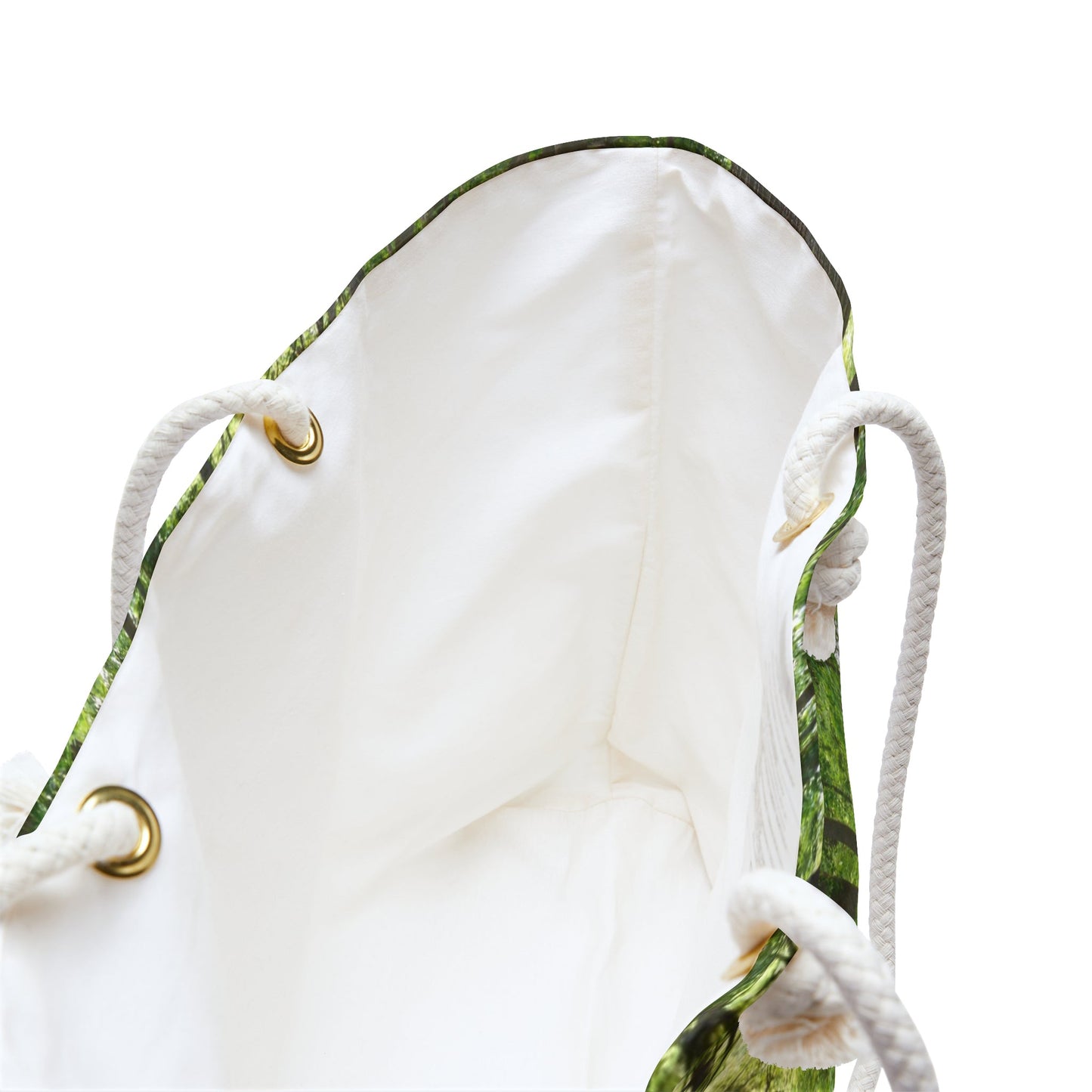 A close up view of the beach bag with forest wildflowers design shows the braided rope handles with metal grommets.