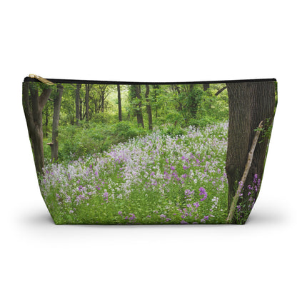 Zippered accessory pouch featuring vibrant photo art of a forest hillside filled with lilac colored wildflowers.