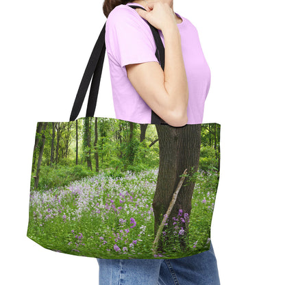 Young woman with a weekender bag featuring the forest wildflowers design hanging from her shoulder.