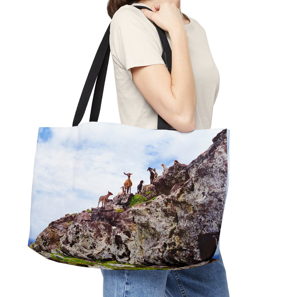 Young woman with a weekender bag featuring the curious goats design hanging from her shoulder.