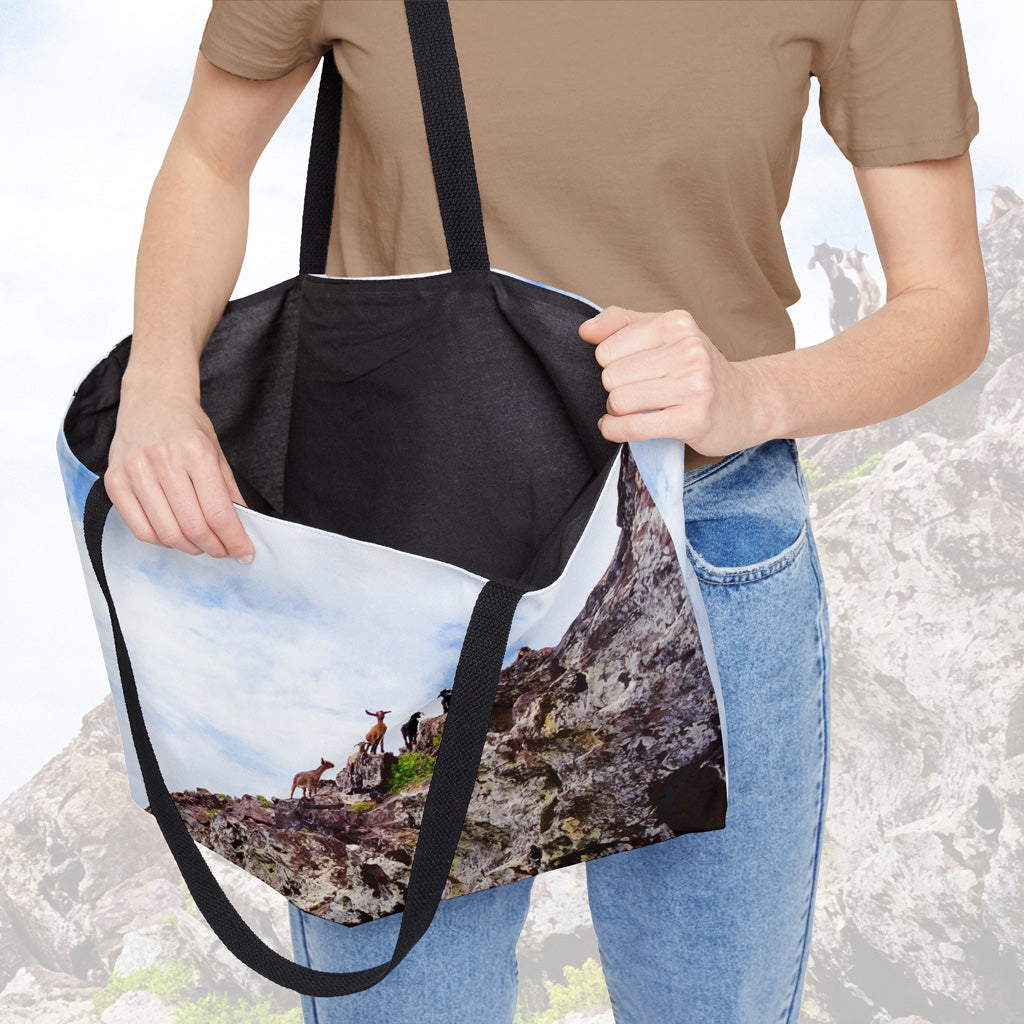 A woman holding open a weekender bag featuring the curious goats design, showcasing the roomy interior.