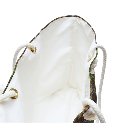 A close up view of the beach bag with green mossy bark design shows the braided rope handles with metal grommets.