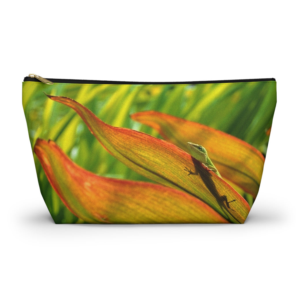 Zippered accessory pouch featuring vibrant photo art of a sunlit green gecko with shadow trying to hide in leaves.