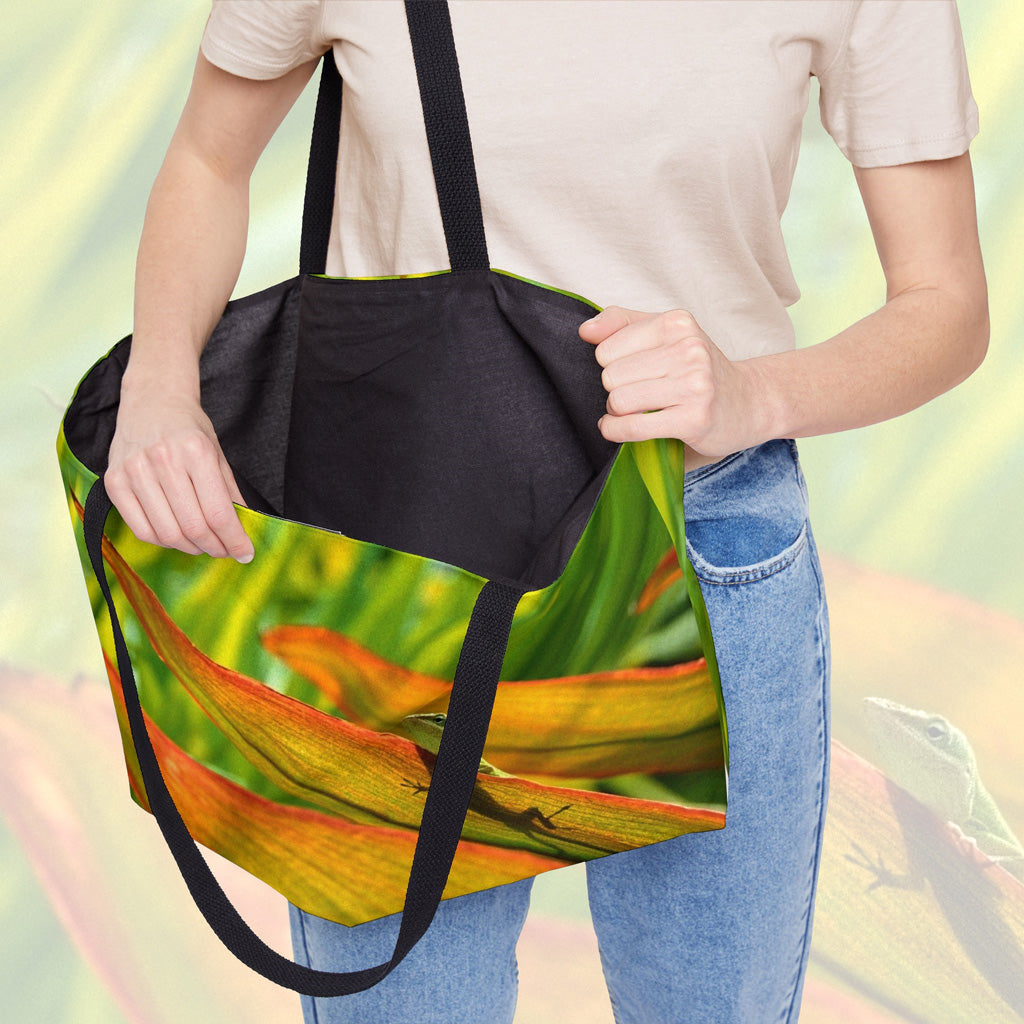 A woman holding open a weekender bag featuring the sunlit gecko design, showcasing the roomy interior.