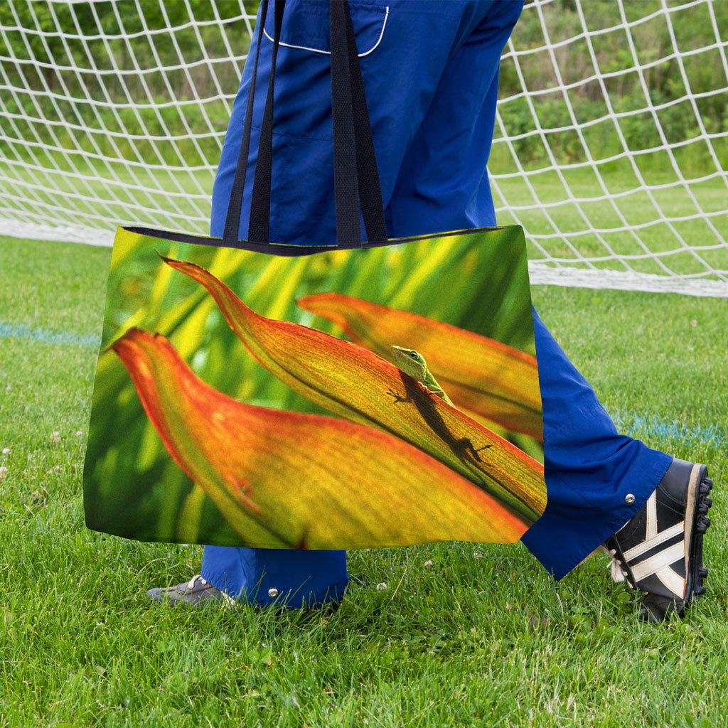 A soccer player carrying a weekender bag featuring the sunlit gecko design onto the practice field.