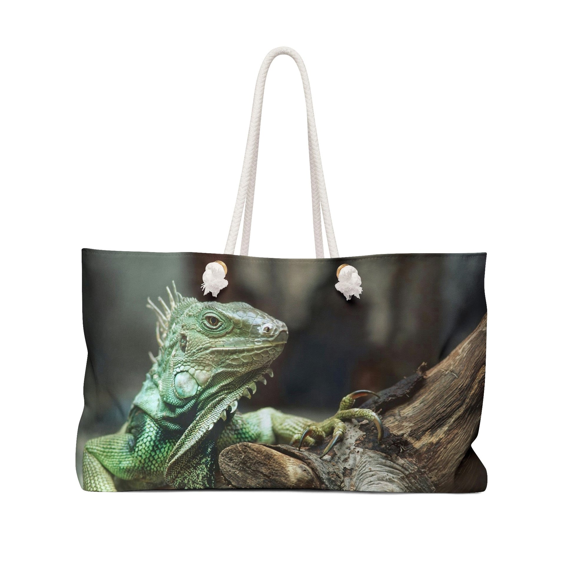 Front view of a beach bag featuring vibrant photo art close up of a regal looking green iguana perched on a thick branch.
