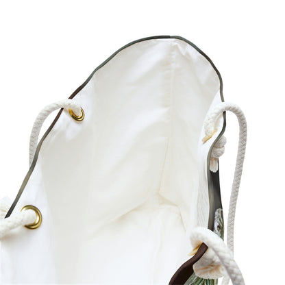 A close up view of the beach bag with green iguana design shows the braided rope handles with metal grommets.
