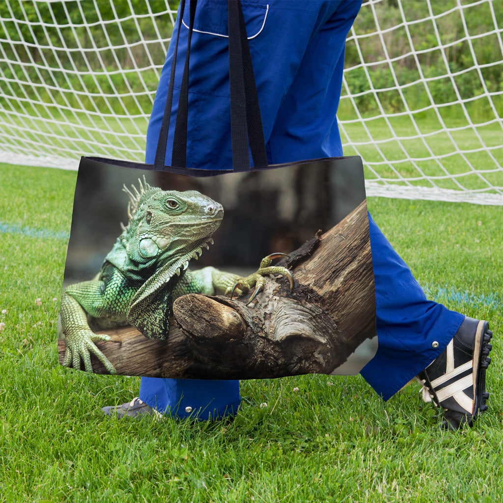 A soccer player carrying a weekender bag featuring the green iguana design onto the practice field.