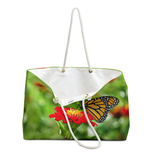 An open view of the beach bag with butterfly on flower design shows the cream colored interior lining.