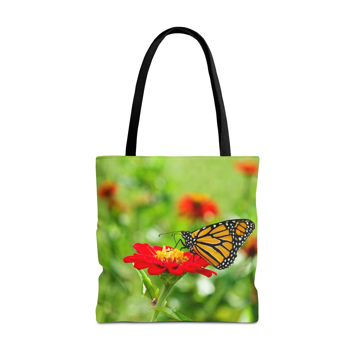 Large 18 x 18 inch tote bag featuring vibrant photo art close up of a monarch butterfly perched on a large red flower.