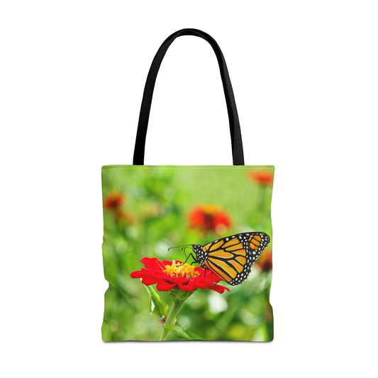 Large 18 x 18 inch tote bag featuring vibrant photo art close up of a monarch butterfly perched on a large red flower.